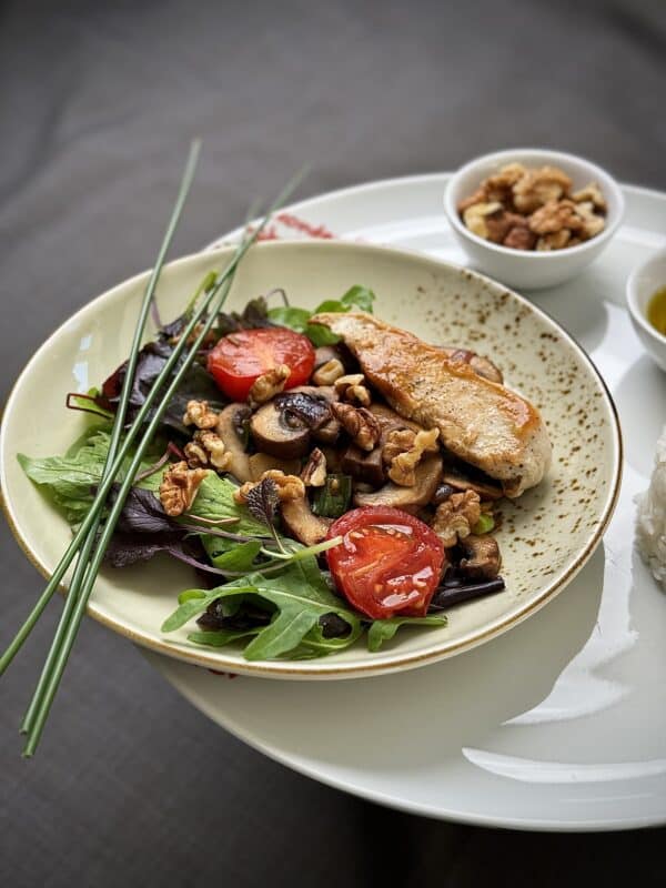 grilled chicken salad with vegetables and walnuts side view