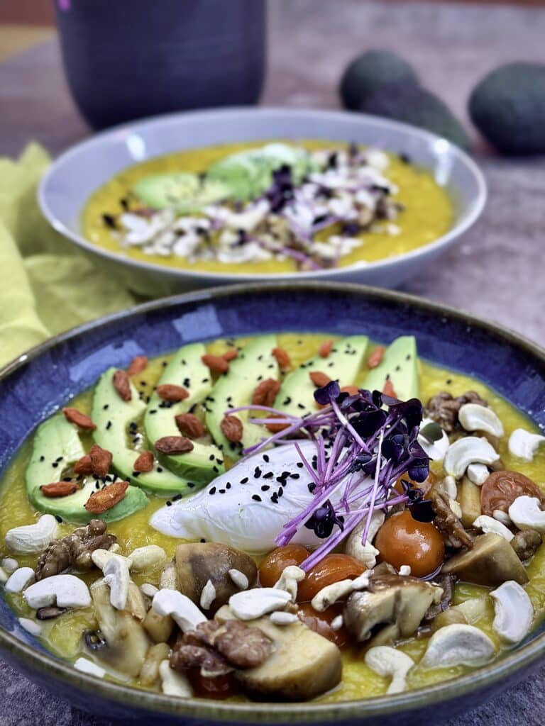 Two version of the pumpkin, potato, parsnip veloute, the blue bowl in from and the grey bowl blurries in background