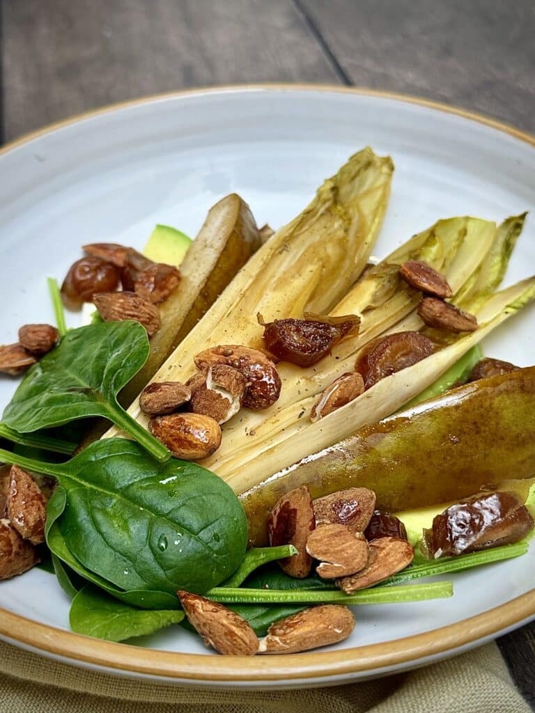 Close-up of caramelized pear, chicory, feta, avocado, and almonds