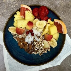 High-fibre breakfast bowl with oats, berries, mango, grapefruit and almonds.
