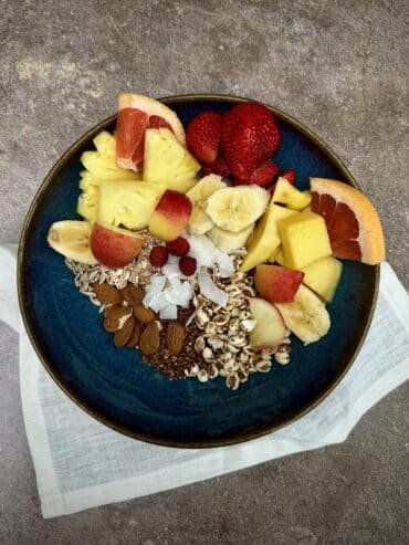 High-fibre breakfast bowl with oats, berries, mango, grapefruit and almonds.