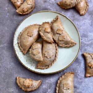 Overhead view of baked healthy wholemeal empanadas on a plate.
