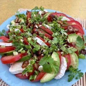 tomato goat cheese avocado salad with dates fresh herbs and edible flowers