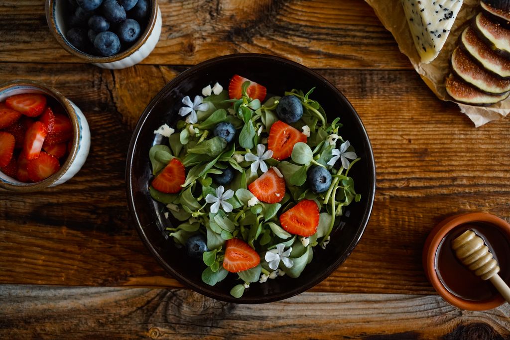 colorful salad with edible flowers showing plant diversity inspiration for tomato goat cheese avocado salad